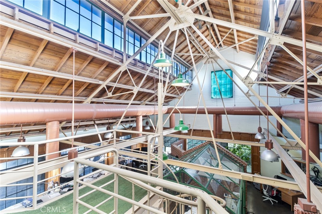 Dramatic soaring timber trusses and steel beams inside the historic atrium, golden daylight streaming through tall windows